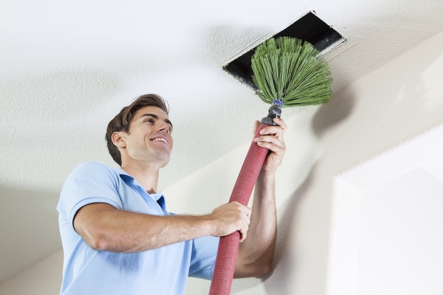 Man cleaning air ducts to eliminate mold